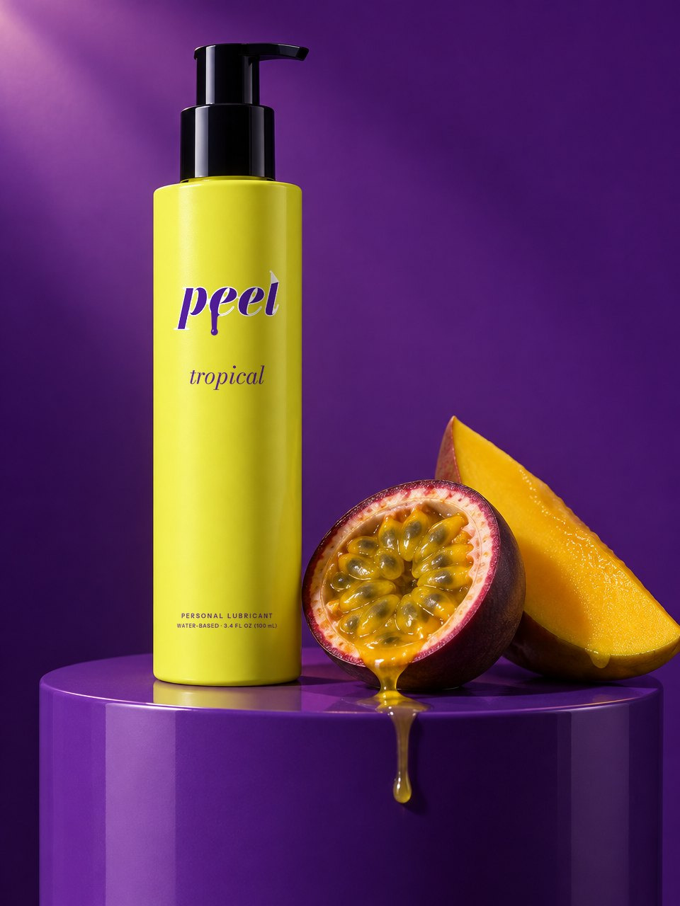PEEL tropical: an acid yellow sleeved bottle on a violet set, beside a dripping passion fruit and mango
